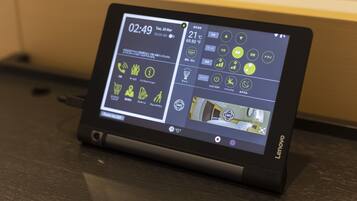 A Lenovo tablet displaying a digital interface with various icons and a clock.