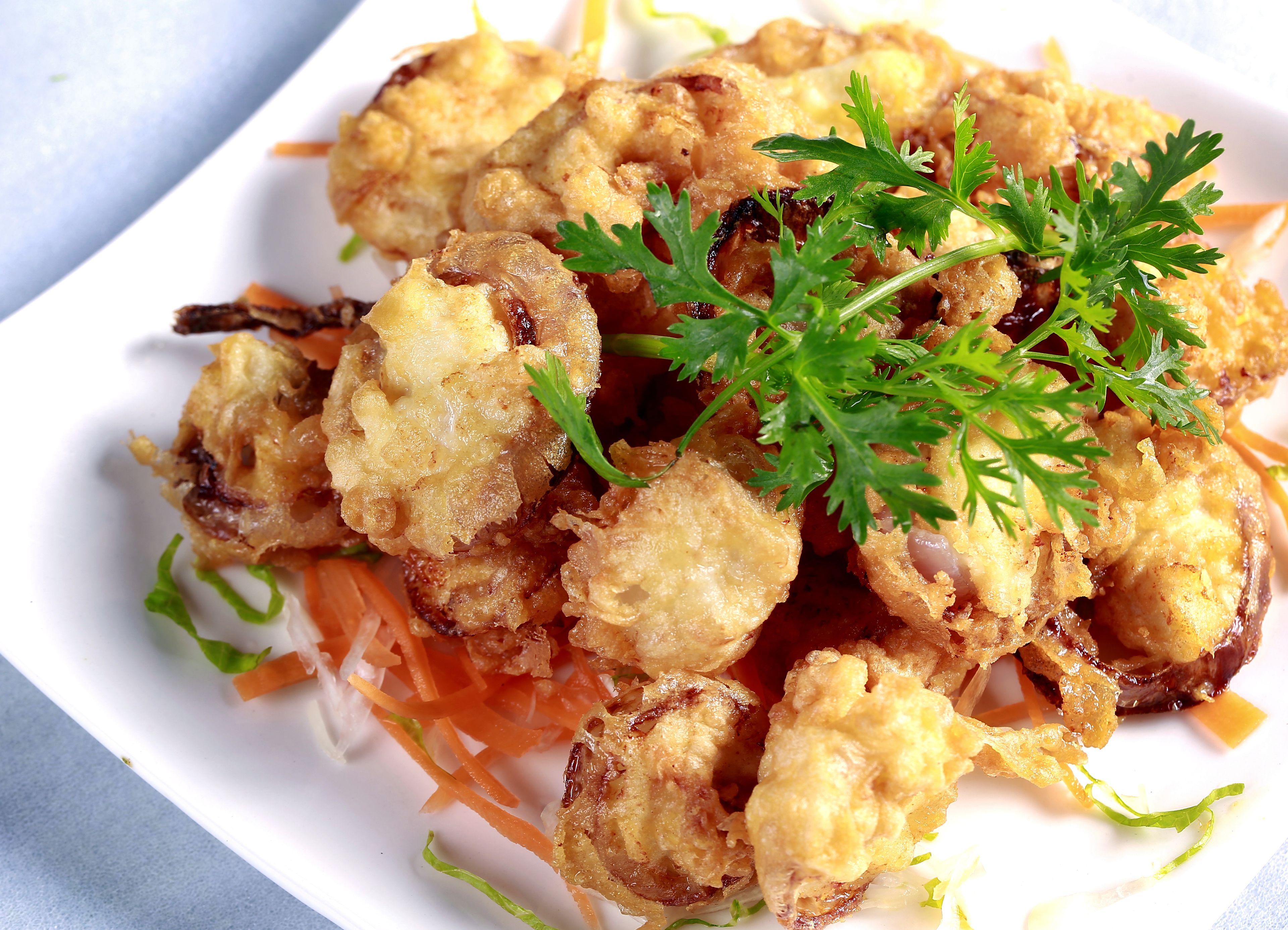 Un plato de comida frita adornado con perejil.
