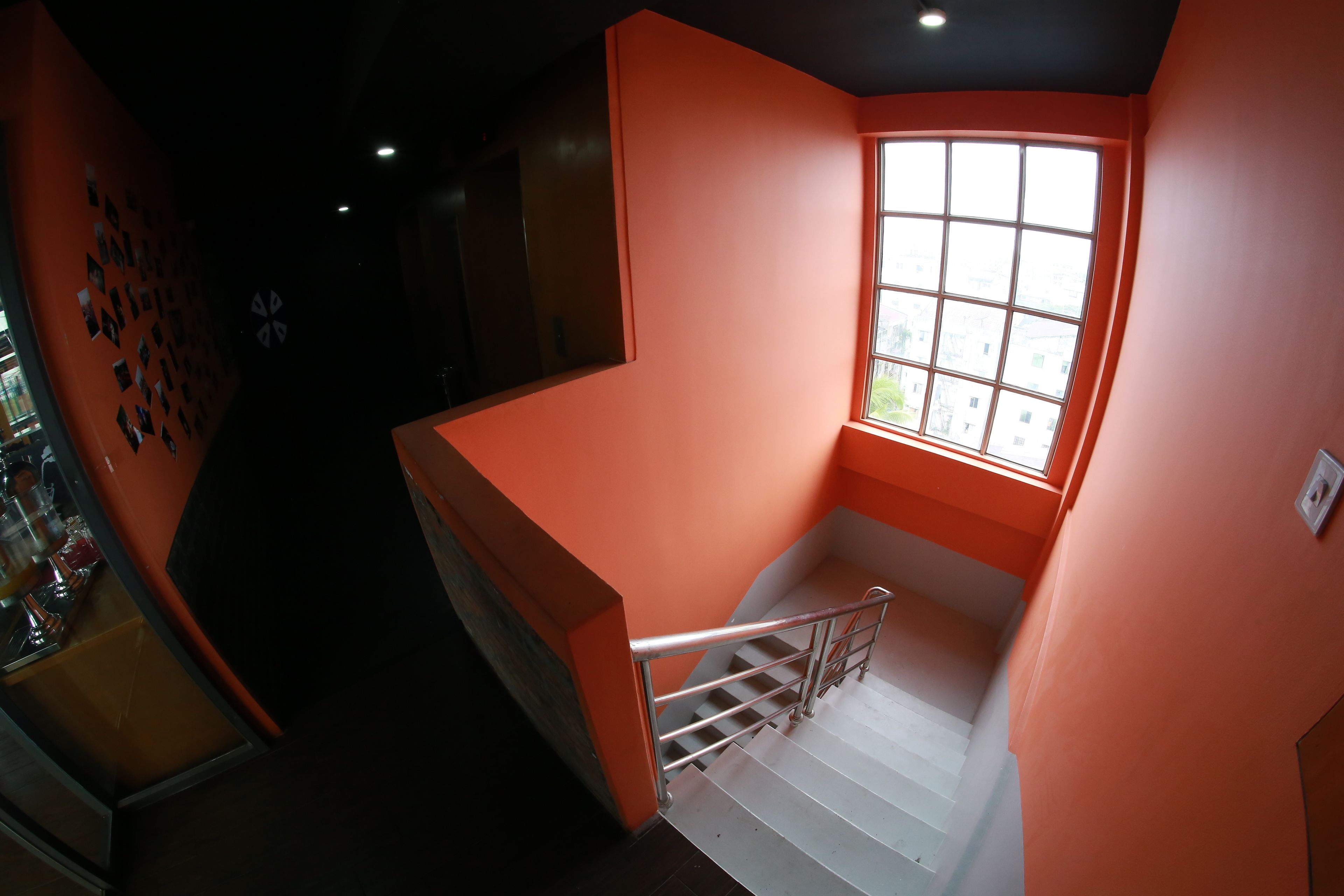 A staircase with orange walls and a window at the top.