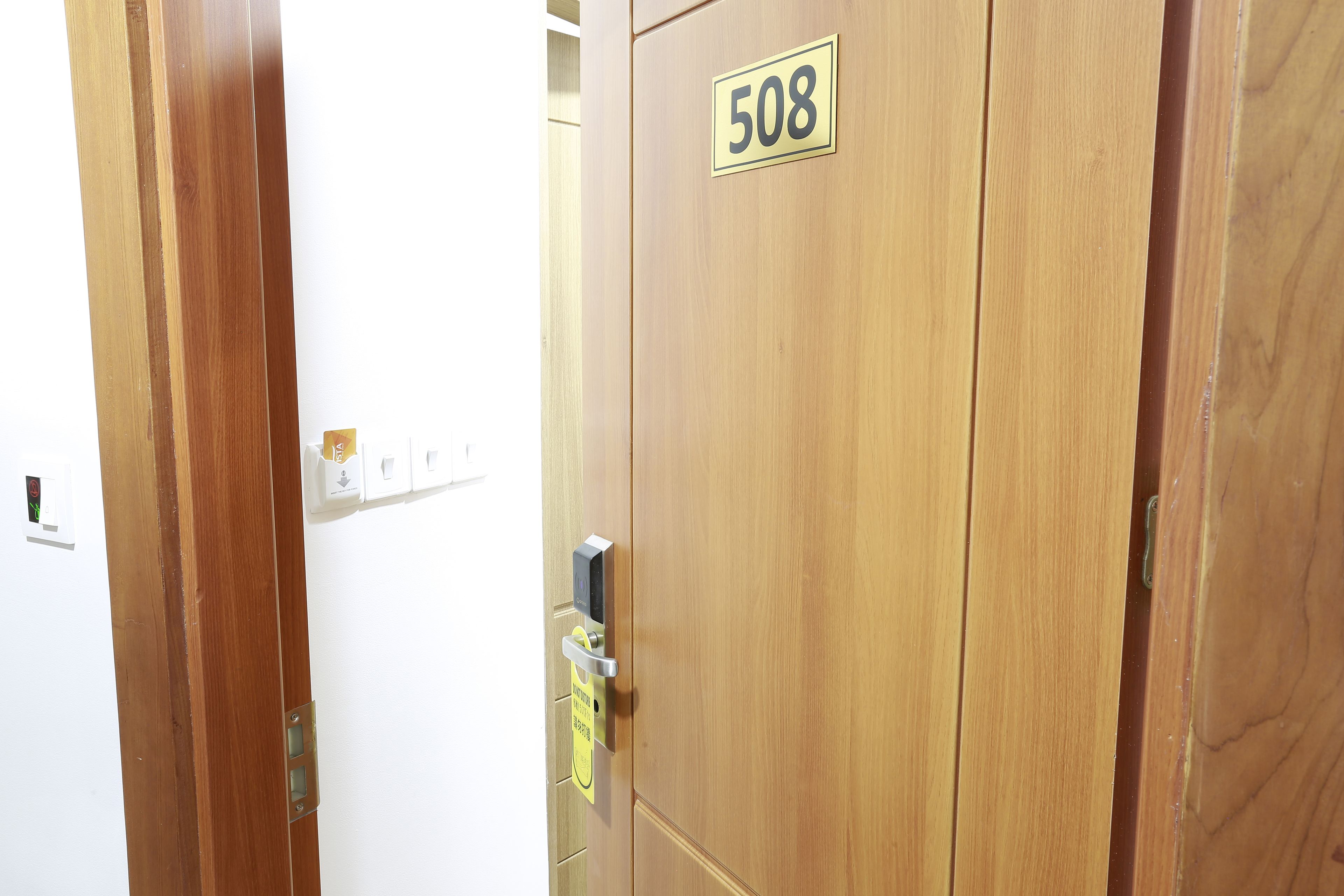 A wooden door with the number 508, a door handle, and a keypad lock.