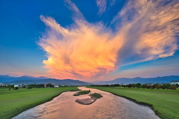 A river flowing through a green landscape with mountains in the background. - The Sunbeam Hideaway Bed & Breakfast (Luodong)