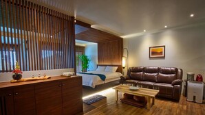 Uma sala de estar moderna com sofá, mesa de centro e cama com cabeceira de madeira.