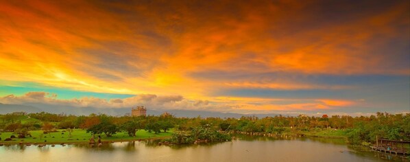 A park with a large body of water, trees, and a distant building. - The Sunbeam Hideaway Bed & Breakfast (Luodong)
