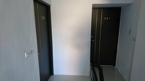 Deux portes, portant les numéros 202 et 201, indiquent les numéros des chambres dans un couloir.