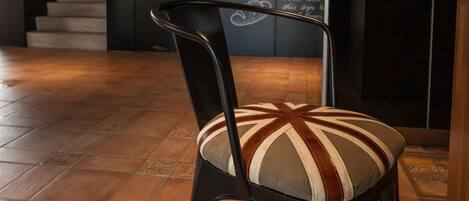 A chair with a striped cushion in a cafe with a mural on the wall.