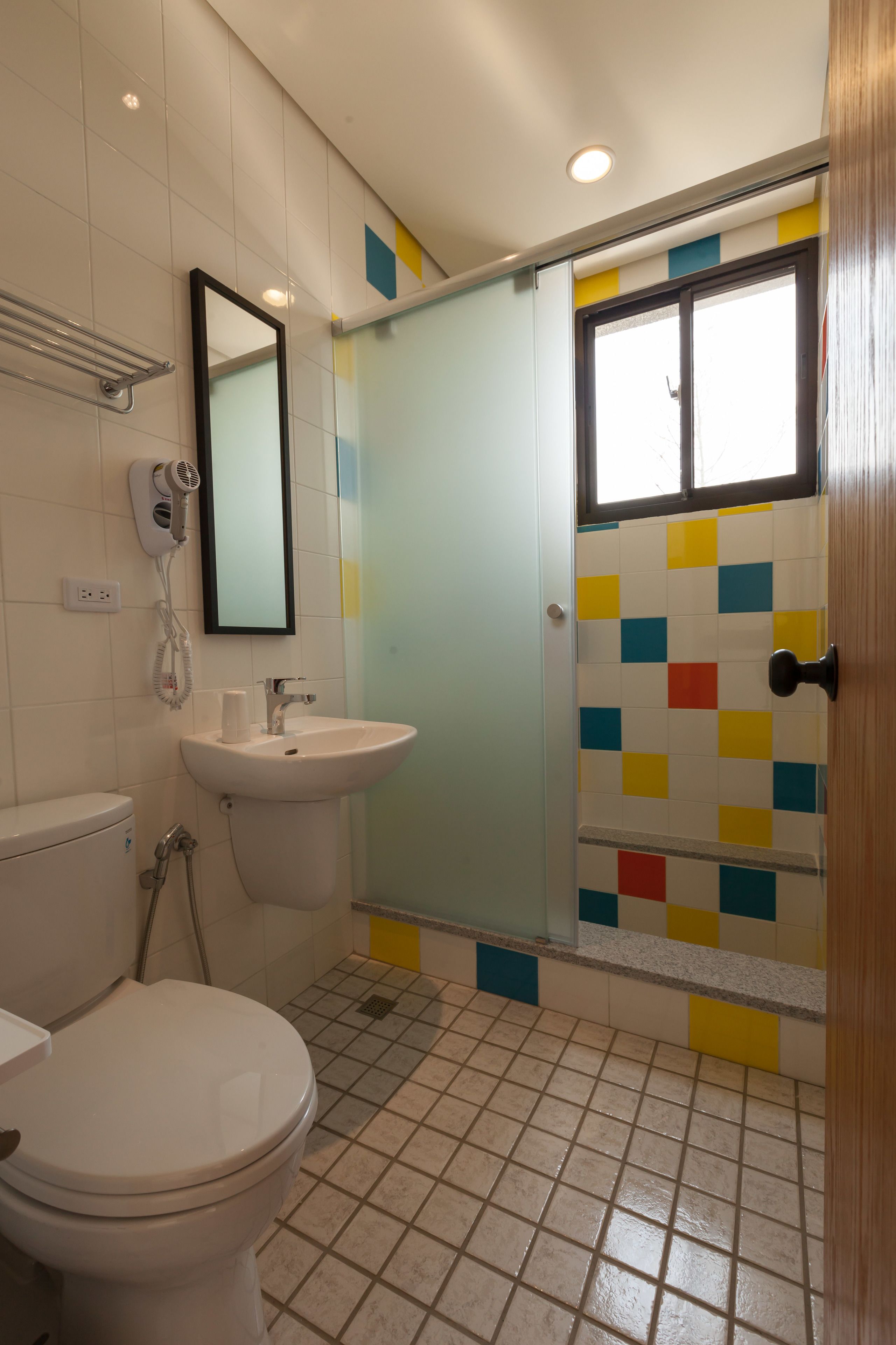 A bathroom with a toilet, sink, and shower.