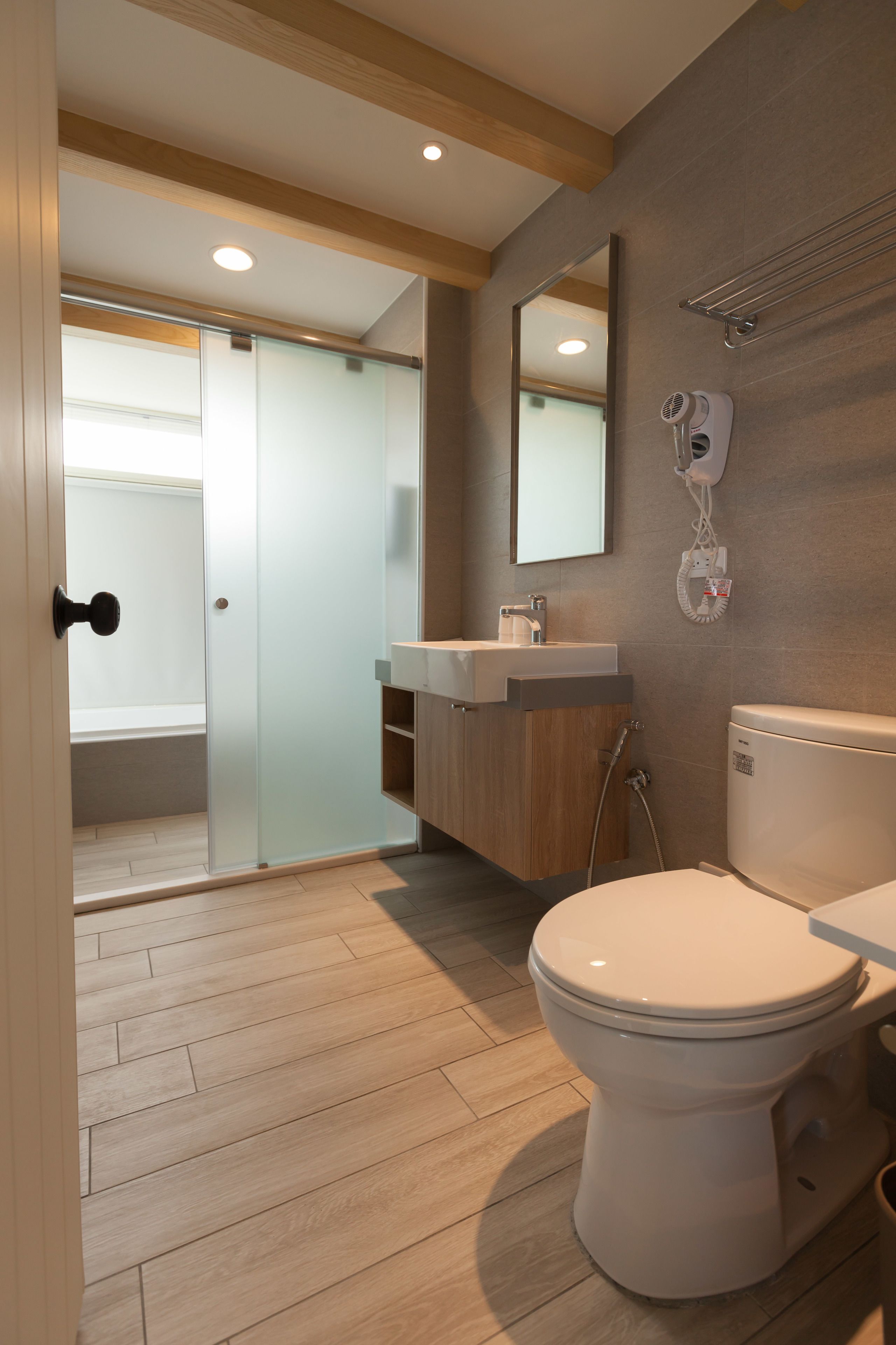 A modern bathroom with a toilet, sink, and shower.