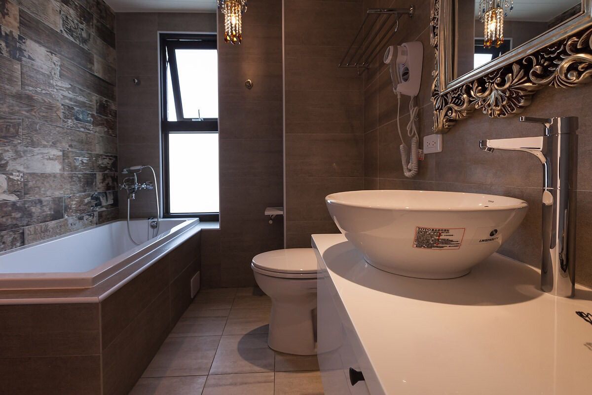 Ein modernes Badezimmer mit einer freistehenden Badewanne, einem großzügigen, ovalen Waschbecken und einer Toilette.