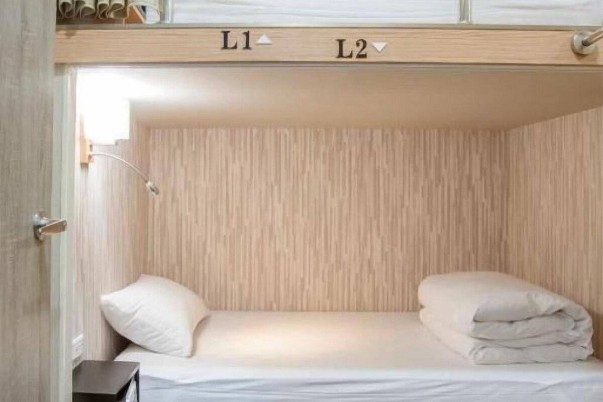 A bunk bed with two labeled sections, L1 and L2, in a room with wooden walls and a wooden floor.