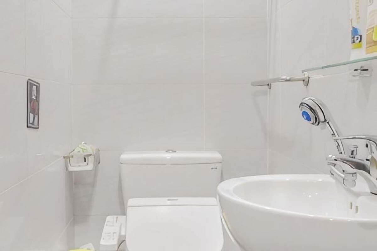 A bathroom with a toilet, sink, and shower.