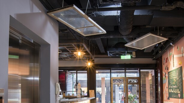 Un interior moderno con área de cocina, taburetes de bar y sillas blancas.