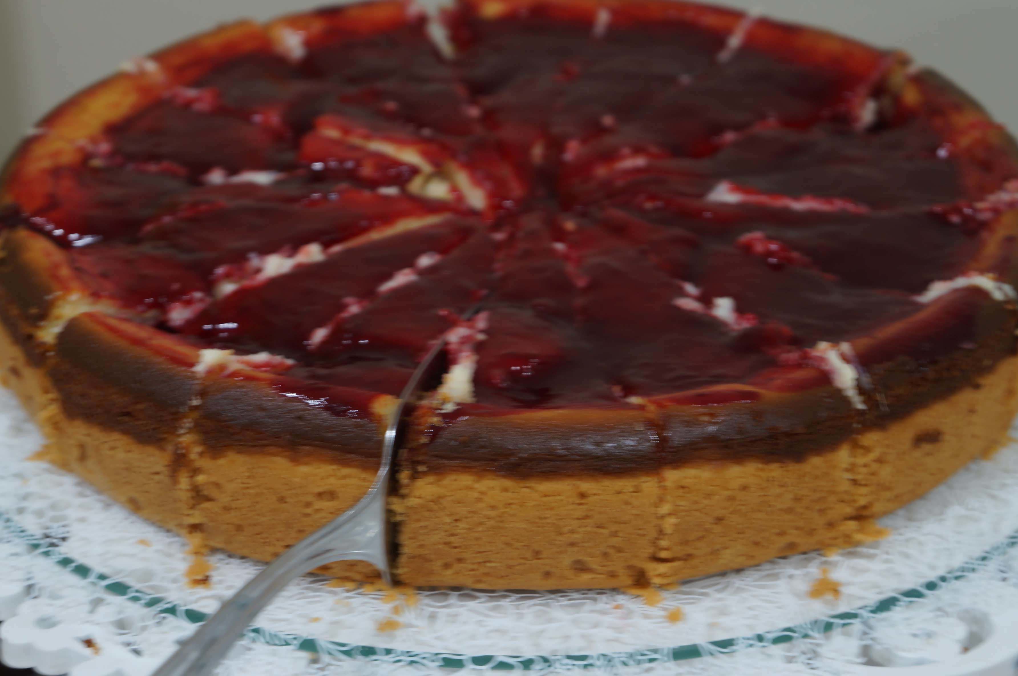 Un gâteau rond, avec une couche supérieure foncée et une couche inférieure plus claire, posé sur un dessous de plat en dentelle.