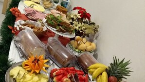 Un tavolo da buffet con diversi cibi, tra cui frutta, verdura e panini.