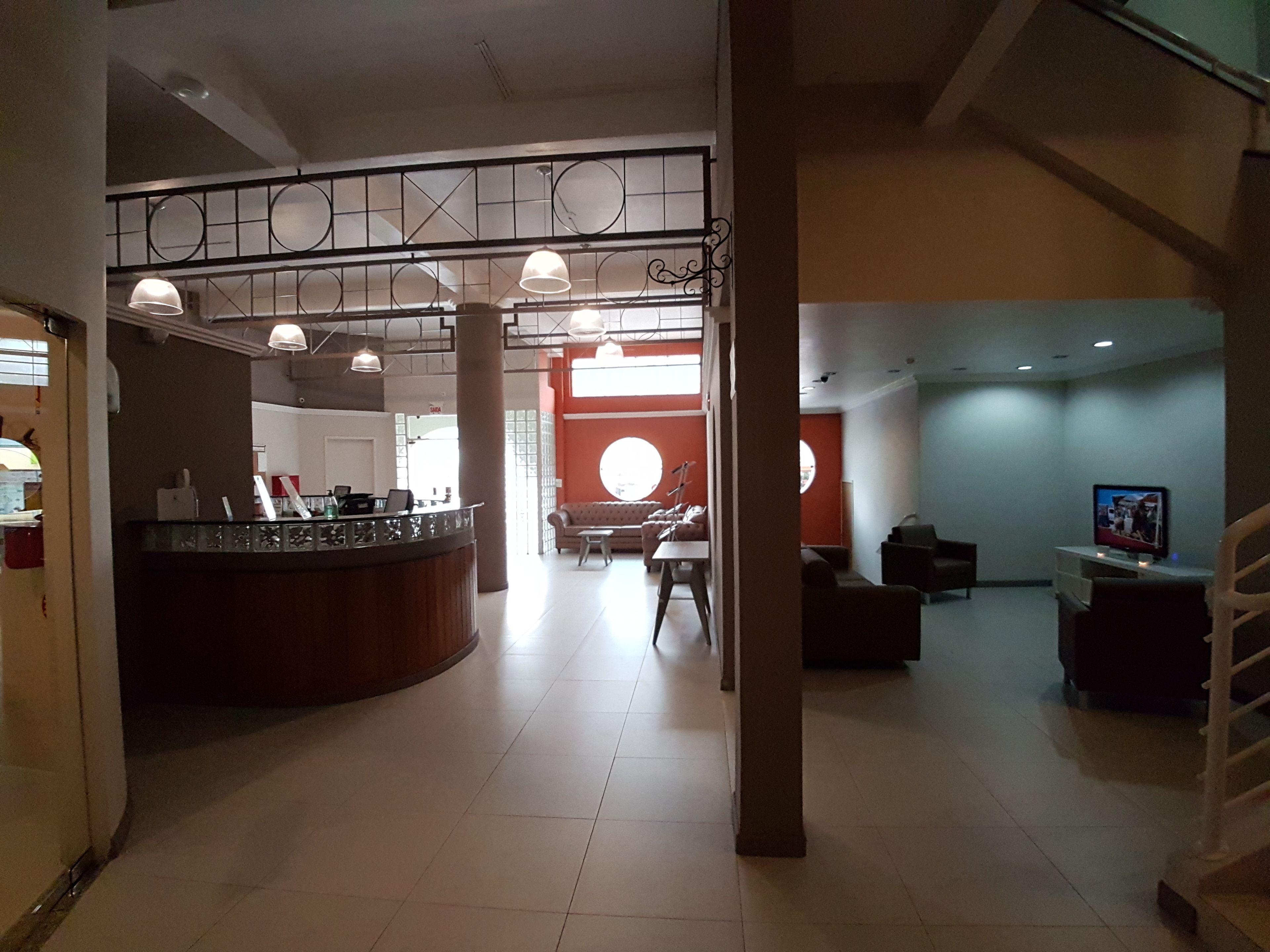 A spacious lobby with a reception desk, seating area, and a staircase.