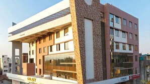 A modern building with multiple floors, large windows, and a prominent entrance. - Galaxy Inn (Kolhapur)