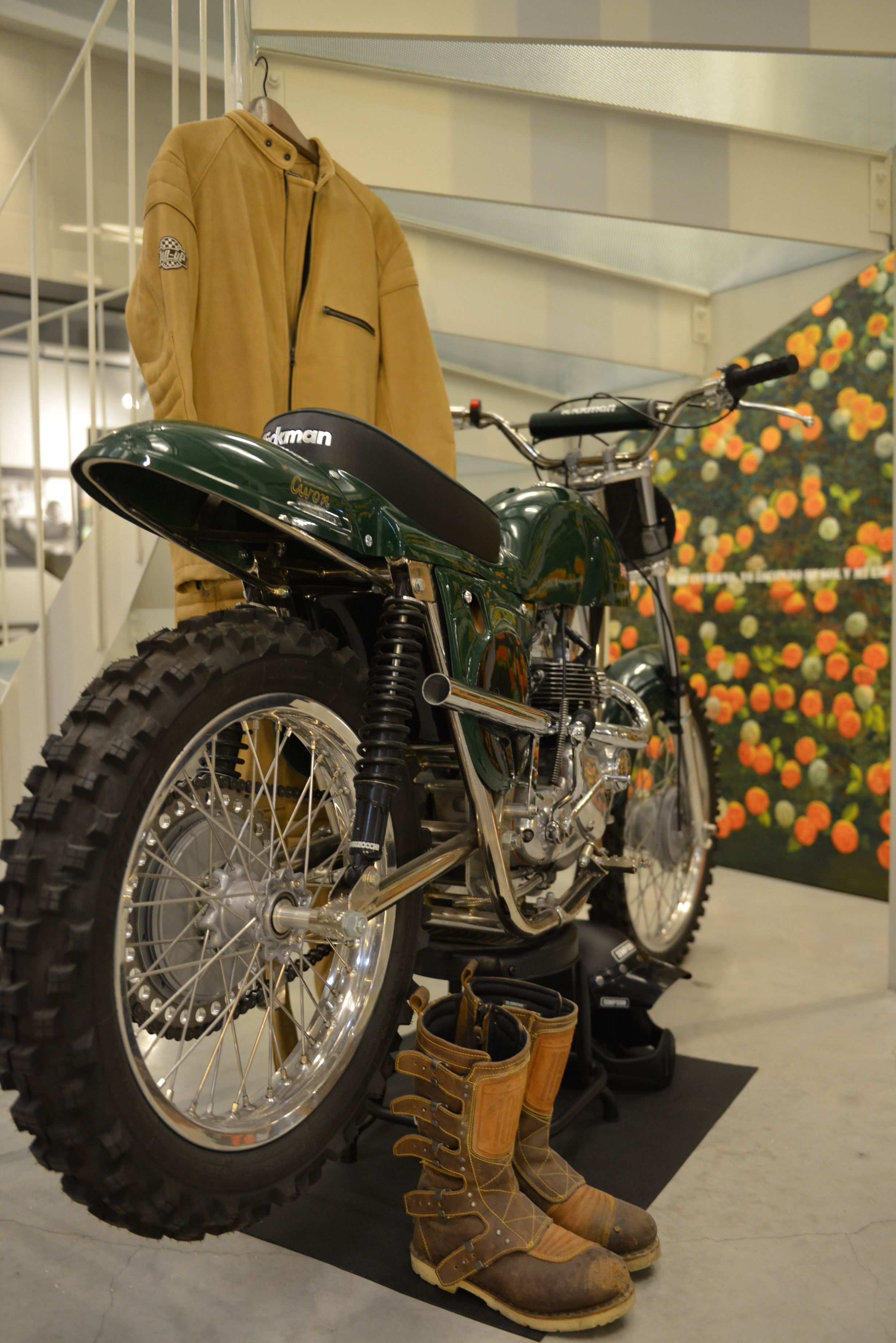 A motorcycle with a large rear tire, a green seat, and a black handlebar.