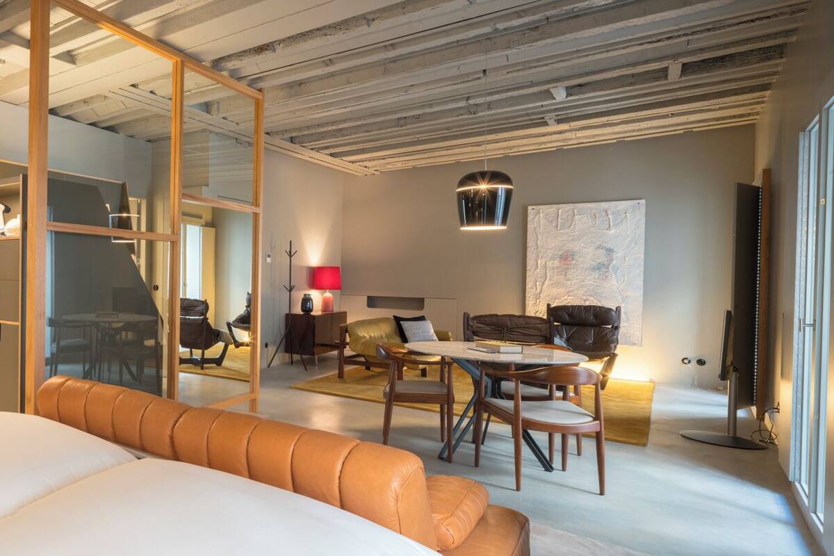Une chambre d’hôtel moderne équipée d’un lit, d’un coin salon et d’une table à manger.