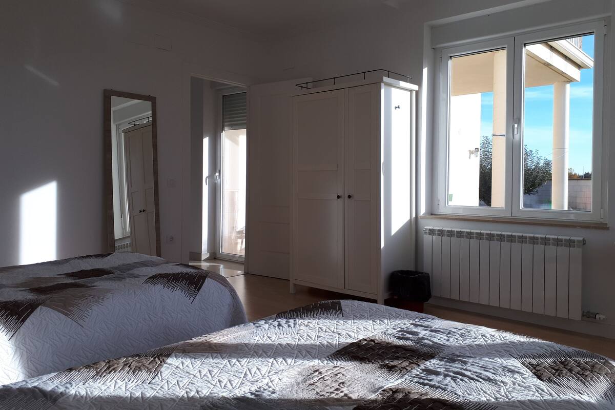 A bedroom with a bed, wardrobe, and a window.