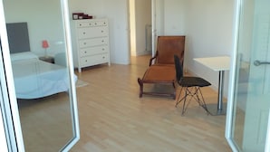 Ein Schlafzimmer mit einem Bett, einem Schminktisch, einem Sessel und einem Schreibtisch.