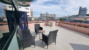 Una terrazza sul tetto con mobili in vimini e vista sulla città.