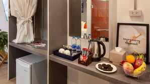 Una camera d'albergo con un minibar, un accappatoio, una macchina del caffè e una ciotola di frutta.