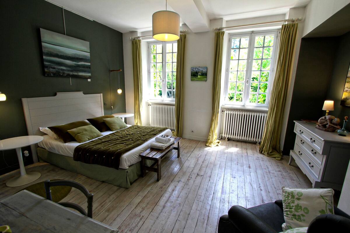 A bedroom with a bed, a bench, a dresser, and a chair.