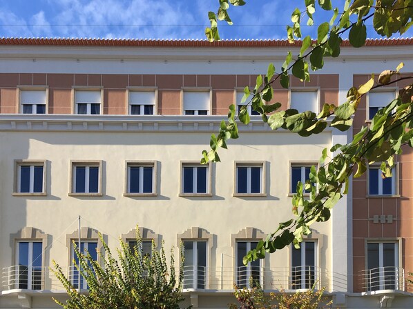 Un immeuble à plusieurs étages, doté d’une façade beige, de nombreuses fenêtres et de balcons.