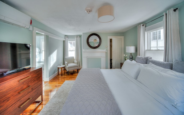A bedroom with a bed, dresser, TV, and a fireplace. - The Sailmaker's House (Portsmouth)
