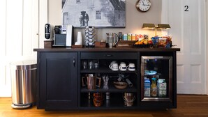 A kitchen counter with a coffee maker, mugs, and a refrigerator containing beverages. - The Sailmaker's House (Portsmouth)