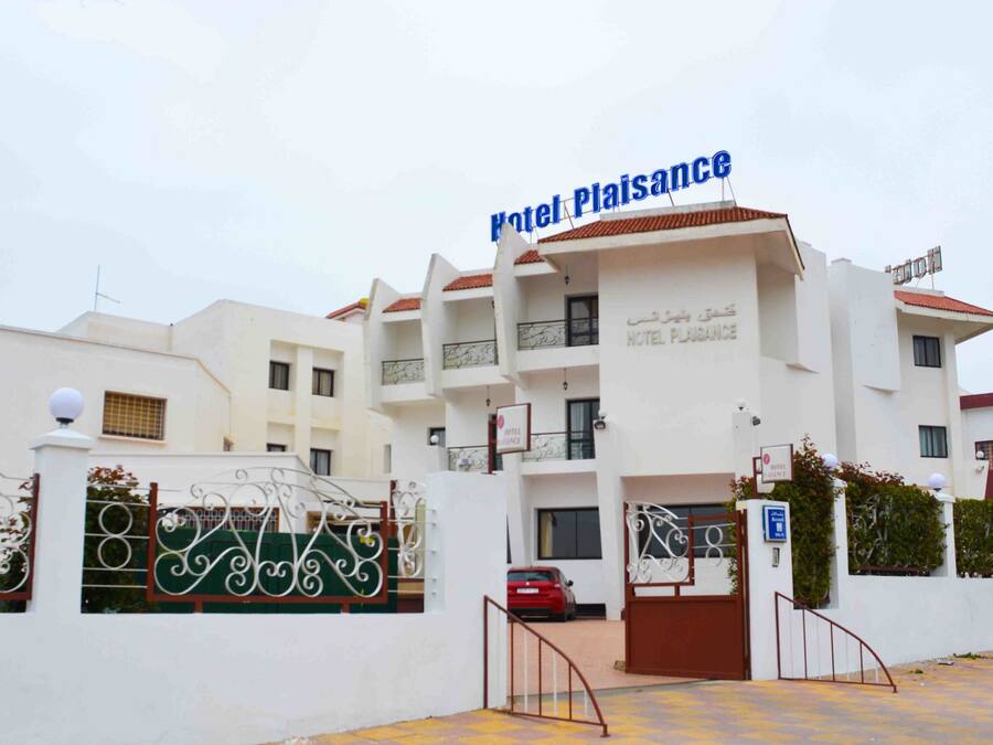 Monikerroksinen hotellirakennus, jonka kyltissä lukee sekä englanniksi että arabiaksi: ”Hotel Plaisance”.