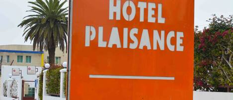 A sign for Hotel Plaisance, indicating it offers a restaurant and parking.