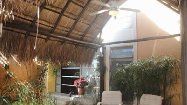 A covered outdoor area with a ceiling fan, two wicker chairs, and potted plants. - Casa Vacacional Cancún 3270 by Sinbad (Cancun)
