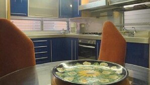 A compact kitchen with blue cabinets, a stove, and a sink. - Casa Vacacional Cancún 3270 by Sinbad (Cancun)
