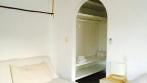 A room with a bed, a white sofa, a small table, and an air conditioning unit. - Hacienda San José 647 by Sinbad (Playa del Carmen)