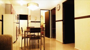 A compact kitchen with a dining area, a refrigerator, and a microwave. - Apartamento Real Ibiza 639 by Sinbad (Playa del Carmen)