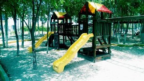A playground with two slides and a climbing structure. - Apartamento Real Ibiza 639 by Sinbad (Playa del Carmen)