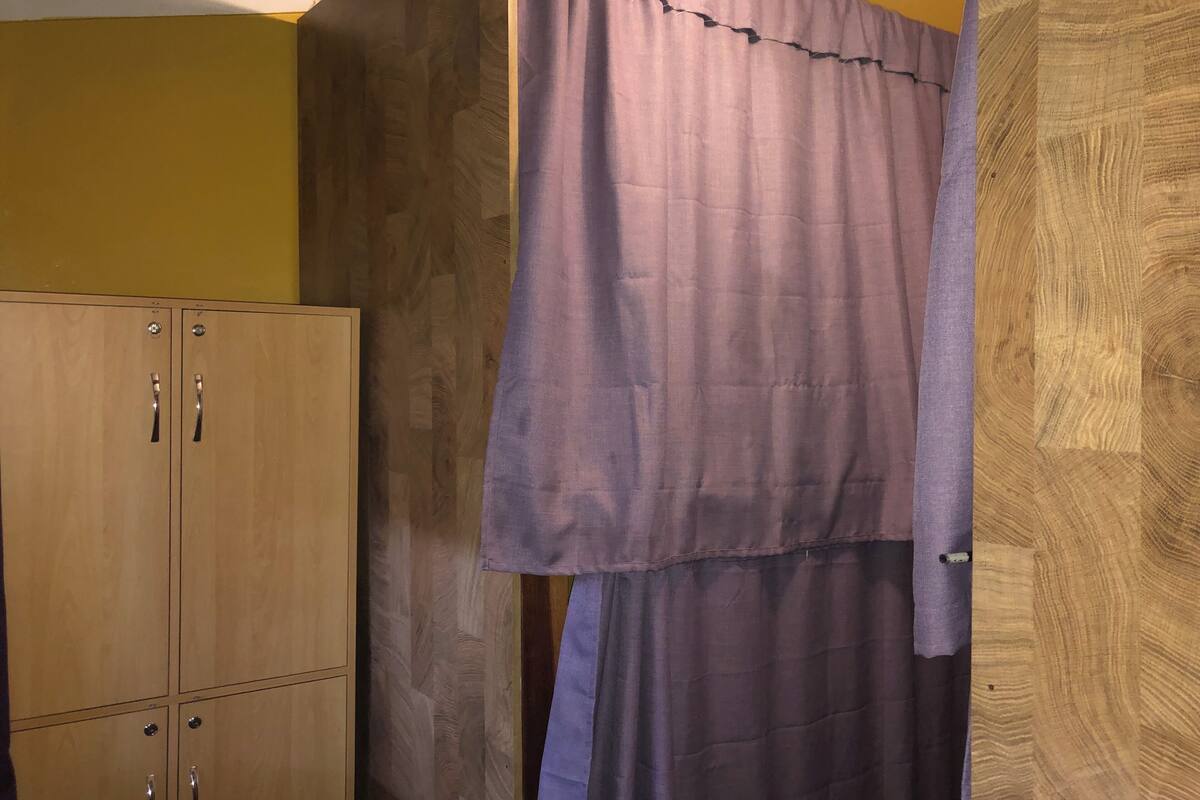 A room with wooden cabinets and a purple curtain.
