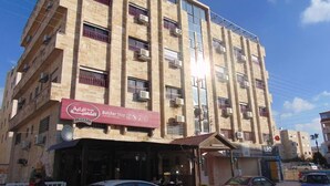 A multi-story building with a butcher shop on the ground floor. - Al-Nujoom Hotel Suites (Amman)