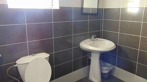 A bathroom with a toilet, sink, and a window. - Al-Nujoom Hotel Suites (Amman)