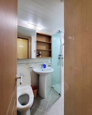 A bathroom with a toilet, sink, and shower. - Khan Residence (Seoul)