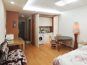 A compact hotel room with a kitchenette, a dining area, and a bed. - Khan Residence (Seoul)