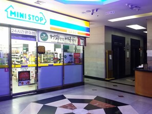 A MiniStop convenience store with a 24-hour service sign, a variety of products, and a CCTV security sign. - Khan Residence (Seoul)
