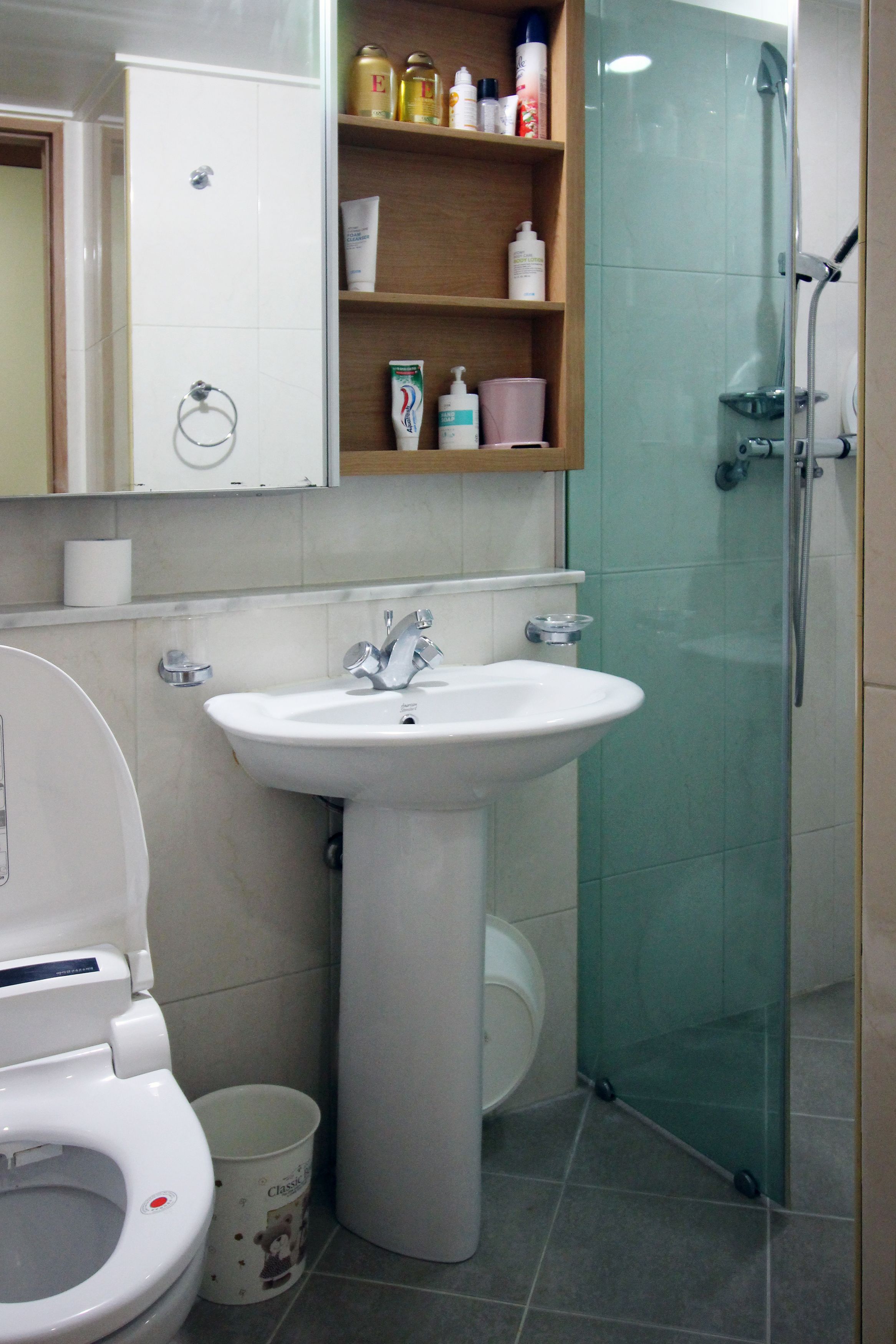 Een badkamer met een witte wastafel, toilet en douchecabine.