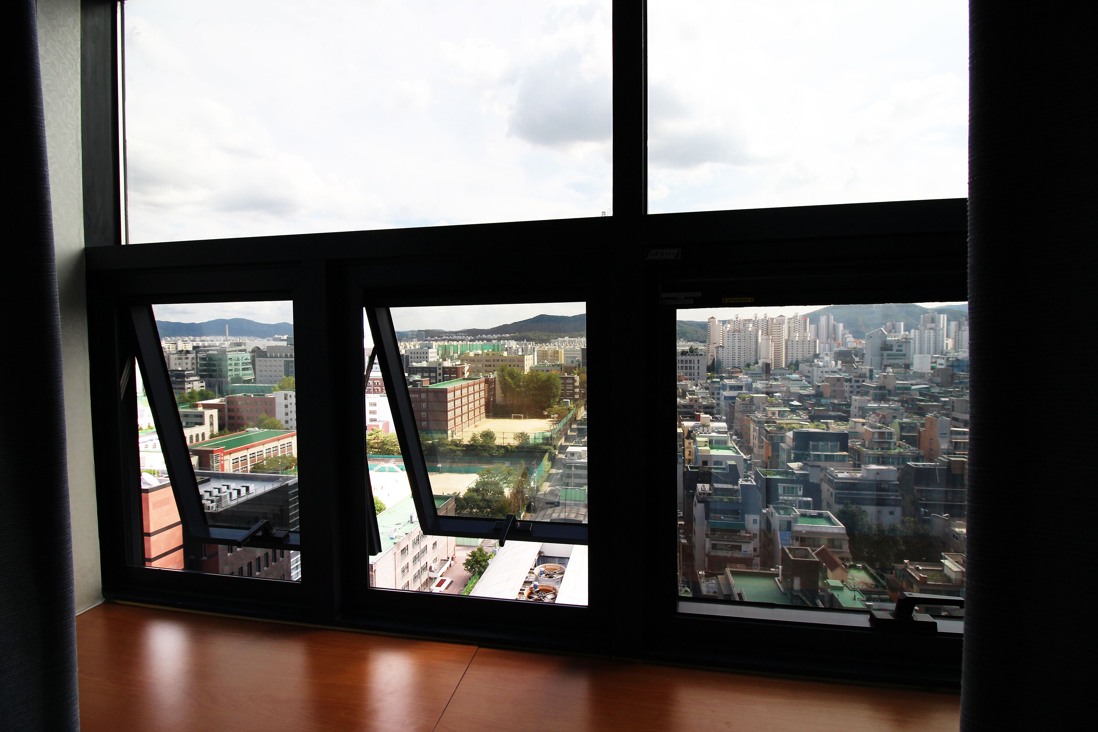 Una habitación con un ventanal grande que da a una vista urbana.