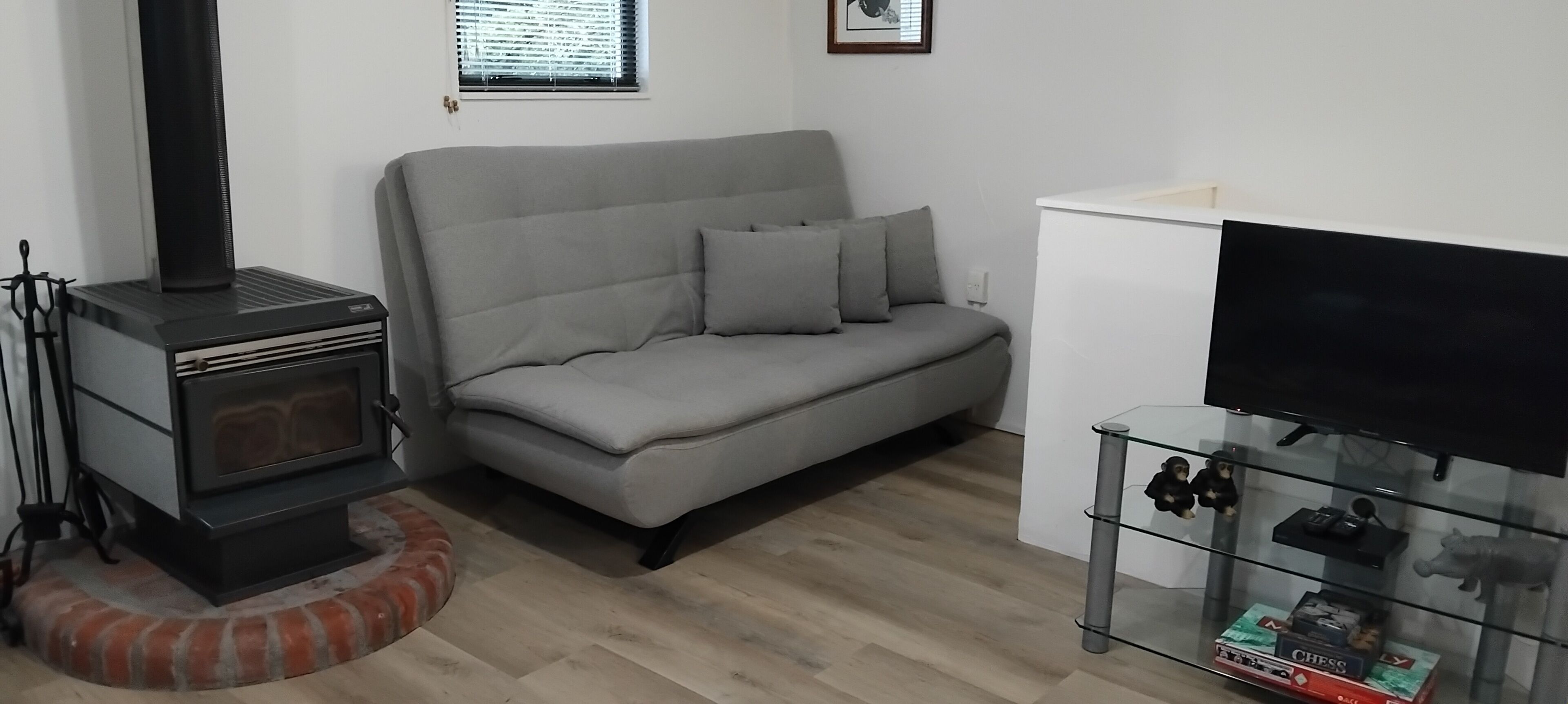 A living room with a sofa, a TV stand, and a fireplace.