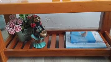 A wooden bench with a vase of flowers and a figurine on it, and a book titled 'Images of a Garden' on the bench.