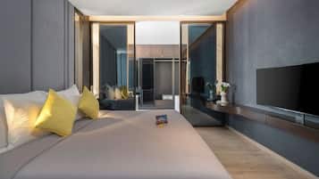 Une chambre d’hôtel moderne dotée d’un grand lit, d’un téléviseur à écran plat et d’une porte coulissante donnant accès à la salle de bain.