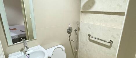 A modern bathroom with a sink, toilet, and shower.