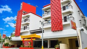 A hotel with a red and white facade, multiple balconies, and a sign indicating a 500 room capacity. - Hotel Sogo Roxas Blvd (Pasay)