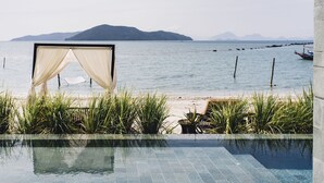 An infinity pool with a view of the sea and distant mountains. - The Beach Samui (Koh Samui)